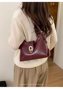Close-up of burgundy retro underarm bag showing oil-wax texture and gold buckle detail