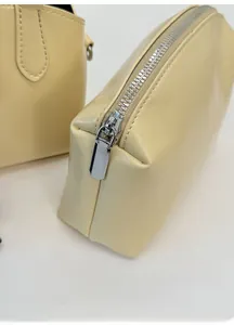 Detail view of cream yellow PU leather zipper pouch showing high-quality metal hardware