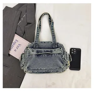 Detailed view of blue denim tote bag size comparison with smartphone and book