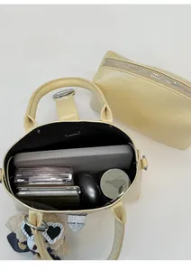 Top view of cream leather tote bag interior showing daily items and silver buckle