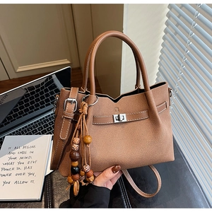 Brown litchi grain tote bag detail with decorative wooden beads and silver twist lock