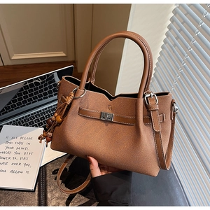 Detailed shot of caramel brown tote bag featuring cross-grain leather and beaded tassel