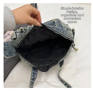 Close-up detail of the denim tote bag interior featuring a black lining and zipper pocket
