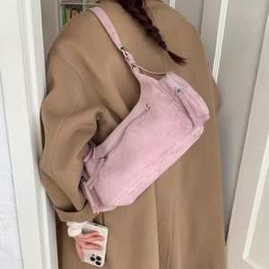 Detail of pink suede shoulder bag with multi-zipper pockets and long tassel fringes