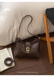 Detail of vintage brown shoulder bag with golden twist lock and textured faux leather finish