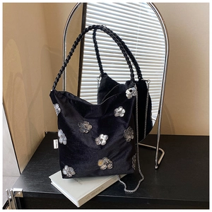 Detail of black velvet tote bag with silver sequin camellia flower and chain strap