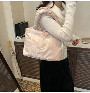 Detailed view of pink jacquard tote bag with traditional embroidery and white tassel detail