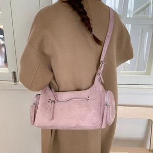 Pink matte crossbody bag shown on model featuring multiple functional silver zippers