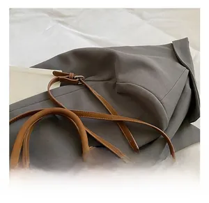 Detailed macro view of the brown leather texture and adjustable silver buckle on the handbag