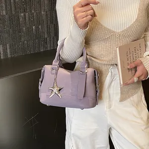 Détail du sac à main lavande texturé avec pendentif étoile argentée et poignée solide