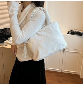 Detail of embroidered tote bag with traditional motifs and elegant silk tassels