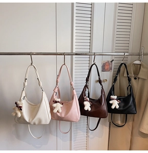 Detailed view of crescent shoulder bags in four colors with cute plush bear charms