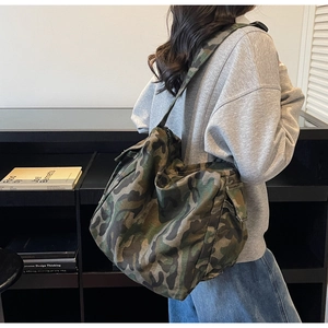 Detail of a camouflage tote bag showing the durable fabric and wide shoulder strap