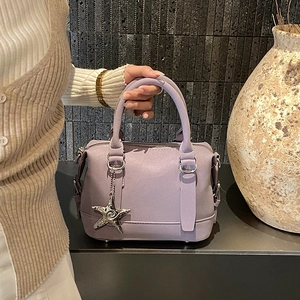 Détail du sac Boston lilas avec pendentif étoile argenté et bandoulière