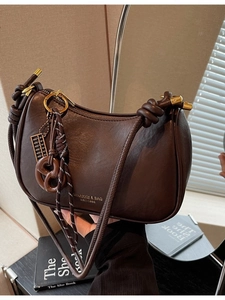 Brown minimalist crescent shoulder bag with knotted handle and tassel details
