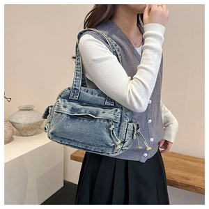 Detail of vintage denim tote bag with cargo-style pockets and washed blue texture
