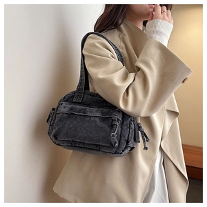 Close-up of retro charcoal grey denim shoulder bag with multi-pocket utility design