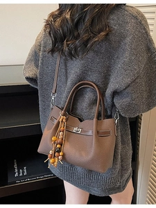 Vintage brown leather tote bag with rotary lock and bohemian beaded tassel accessory