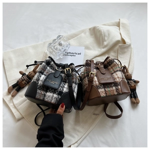 Gros plan de sacs seaux à carreaux avec garniture en cuir et pendentifs lapins