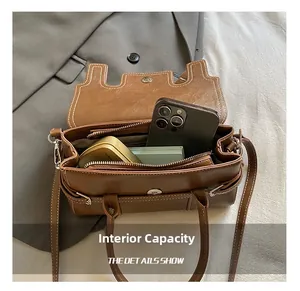 Detail view of the brown PU leather handbag interior showing pockets and daily essentials