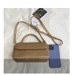 Detail showing khaki faux leather crossbody bag with elegant horizontal embossed texture