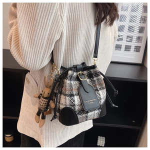 Détail du sac seau en tweed avec cordon de serrage et breloque lapin mignonne