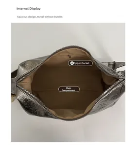 Détail intérieur du sac argenté avec doublure beige et une poche intérieure zippée