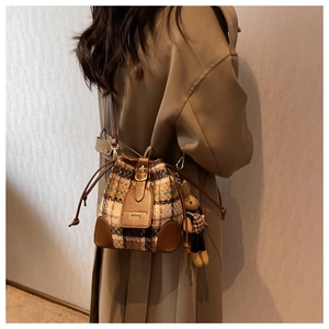 Détail du sac seau à carreaux vintage avec cordon de serrage et pendentif lapin