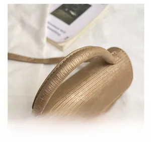 Close-up of a stylish light brown textured handle with fine vertical stitching details
