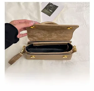 Macro view of light brown flap bag interior with dual compartments and metal clasp