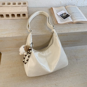 Détail du sac dumpling blanc cassé avec texture froissée, breloque peluche et perles