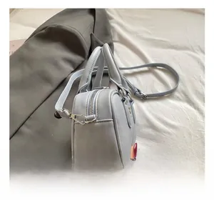 Detailed view of ice blue Boston bag with silver zipper and metallic strap hooks