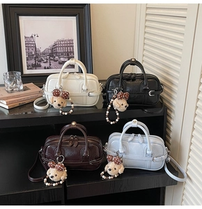 Sacs boston en blanc crème noir marron et bleu avec pendentifs caniche et bandoulières