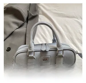Macro shot of light blue boston bag featuring matte leather texture and silver metal logo