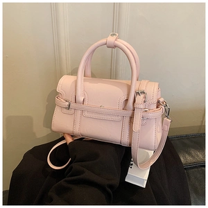 Detail of pink PU leather handbag showing flap closure and buckle decoration