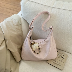 Détail du sac à bandoulière en similicuir rose plissé avec pendentif en peluche doux