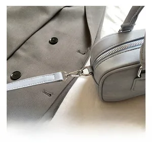 Detail view of the silver-tone metal hardware and zipper closure on the blue leather bag