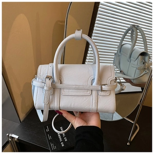 Detail shot of light blue PU leather handbag with silver metal buckle and handle