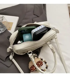 Vue intérieure du sac polochon en cuir crème montrant la grande capacité de rangement