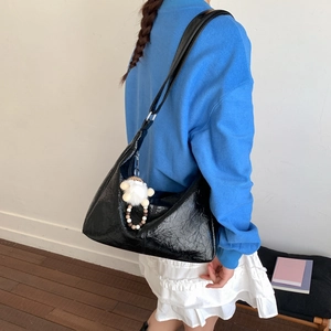 Vue détaillée du sac porté épaule noir en similicuir plissé avec charme mouton blanc