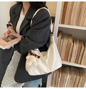 Detail of white PU leather hobo bag with adjustable strap and plush bear charm