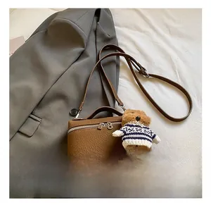 Detailansicht der braunen Leder-Umhängetasche mit niedlichem Plüschbären-Anhänger-Dekor