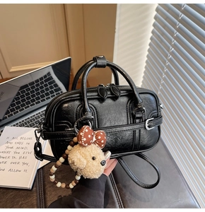 Détail du sac polochon vintage noir en simili cuir avec pendentif ours en peluche et perles