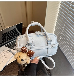 Vue détaillée du sac Boston bleu clair avec texture cuir et adorable charme de chien
