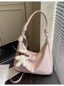 Pink oversized hobo shoulder bag with a plush bear charm and knotted handle design