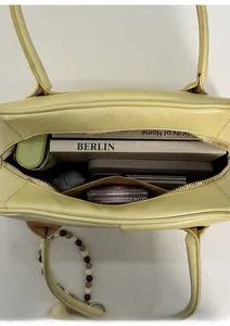 Top view of spacious yellow leather underarm bag showing interior storage for daily items