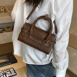Brown vintage handbag showing the size and proportion on a model in a minimalist room