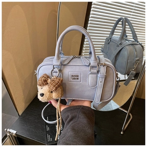 Detail view of fog blue Boston bag with leather texture and bear charm