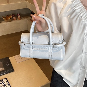 Close-up of light blue structured leather handbag with decorative metal buckle and dual handles