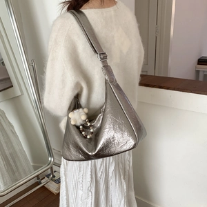 Sac hobo argenté avec texture plissée en vue latérale et charmant petit mouton en peluche